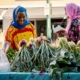 Two women in front of a vegetable market